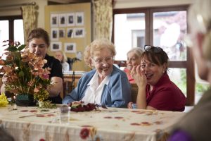 A resident and member of staff sharing a laugh while doing flower arranging at Oakdale Nursing Home in Portarlington