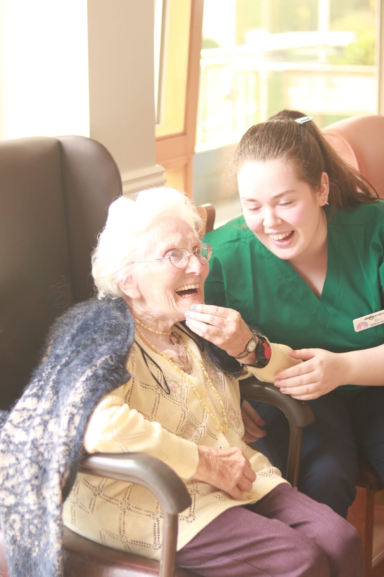 Teach Altra Nursing Home resident laughing with a Healthcare Assistant