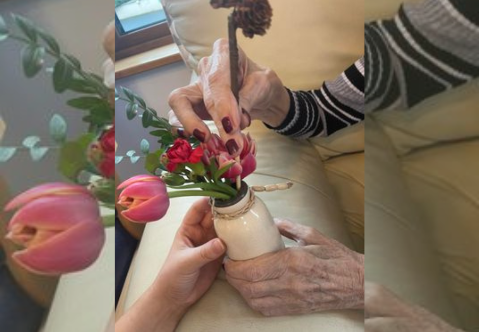 Esker Rí Nursing Home resident placing flowers in a vase