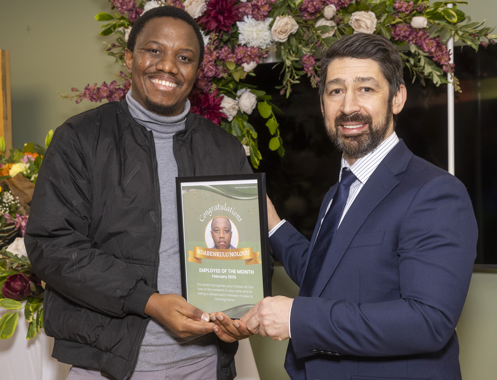 Ndabenkulu Nolouu receiving an Evergreen Care employee recognition award